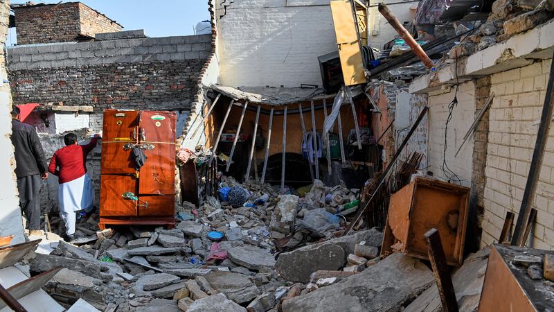 Funcionarios revisan los daños en una casa causada por la explosión de una bombona, horas...